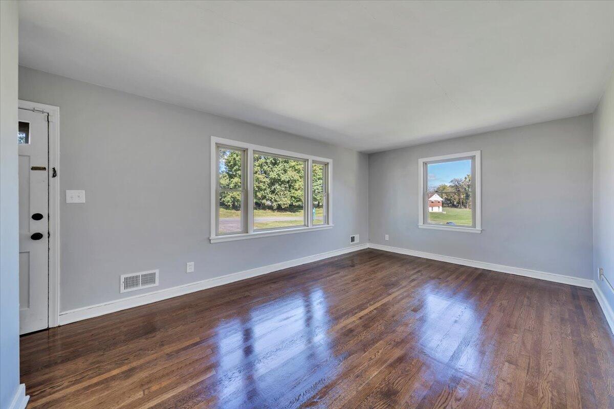 210 Post Road Roanoke, VA 24019 - Photo 5 of 56 an empty room with wooden floor and windows