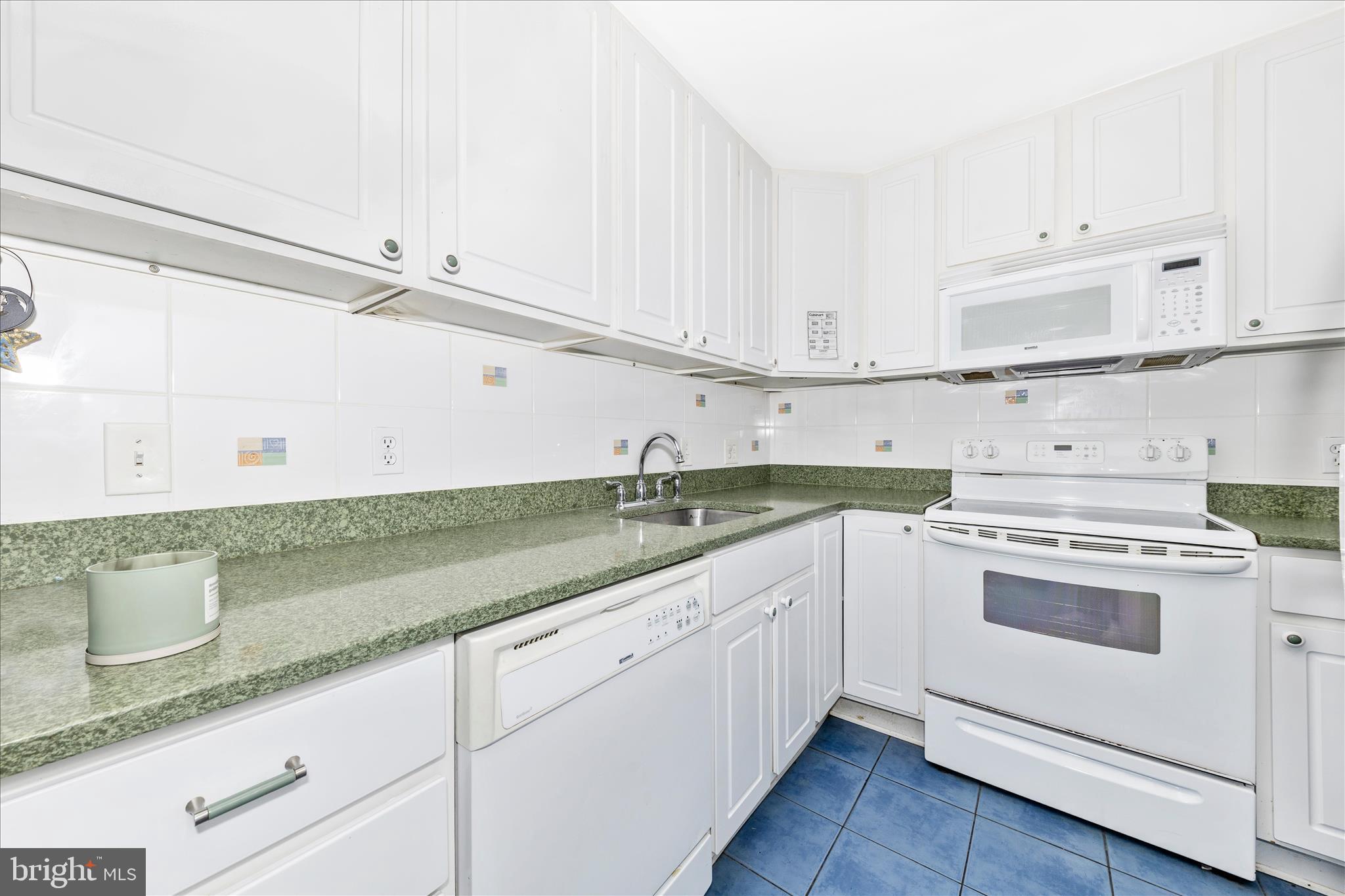11412 Fairoak Drive Silver Spring, MD 20902 - Photo 33 of 48 a kitchen with granite countertop white cabinets and white appliances