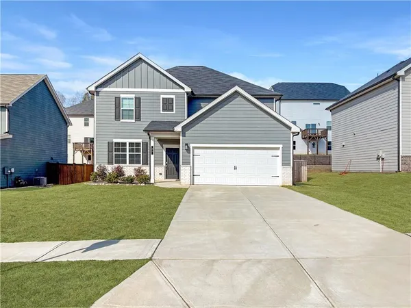 a view of a yard in front of a house with a large tree