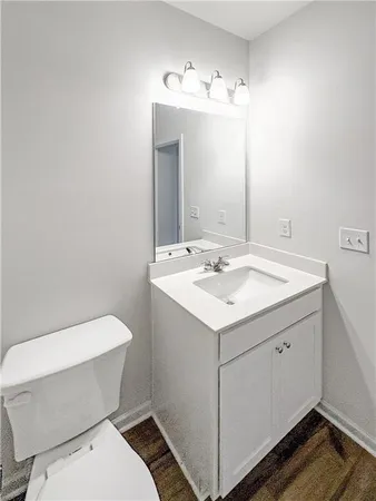 a bathroom with a sink and mirror with toilet