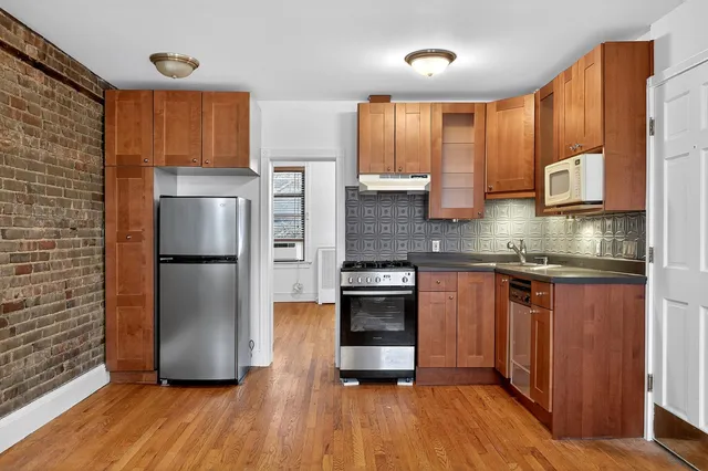 a kitchen with stainless steel appliances a refrigerator sink and microwave