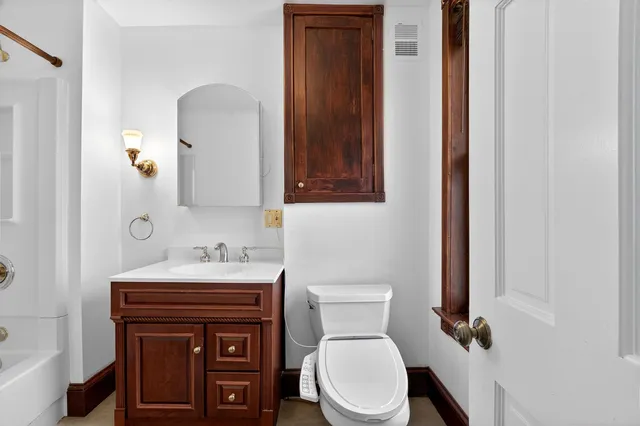 a bathroom with a toilet sink and mirror