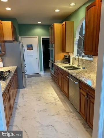 a large kitchen with kitchen island granite countertop a sink and a refrigerator