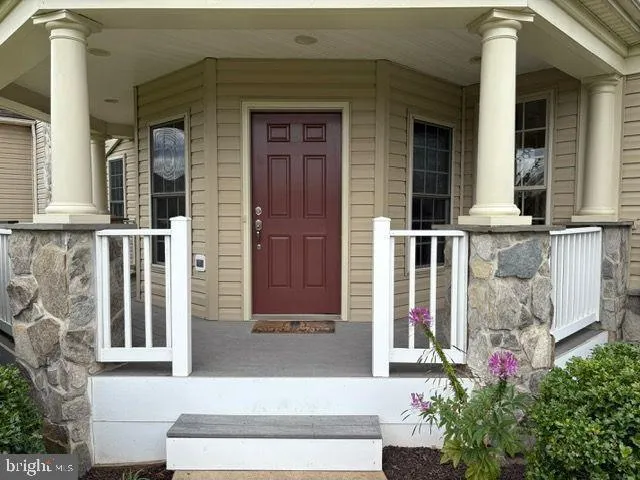 front view of a house with a potted plant and windows