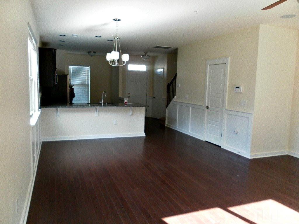 7828 Allscott Way Raleigh, NC 27612 - Photo 11 of 17 an empty room with wooden floor and windows