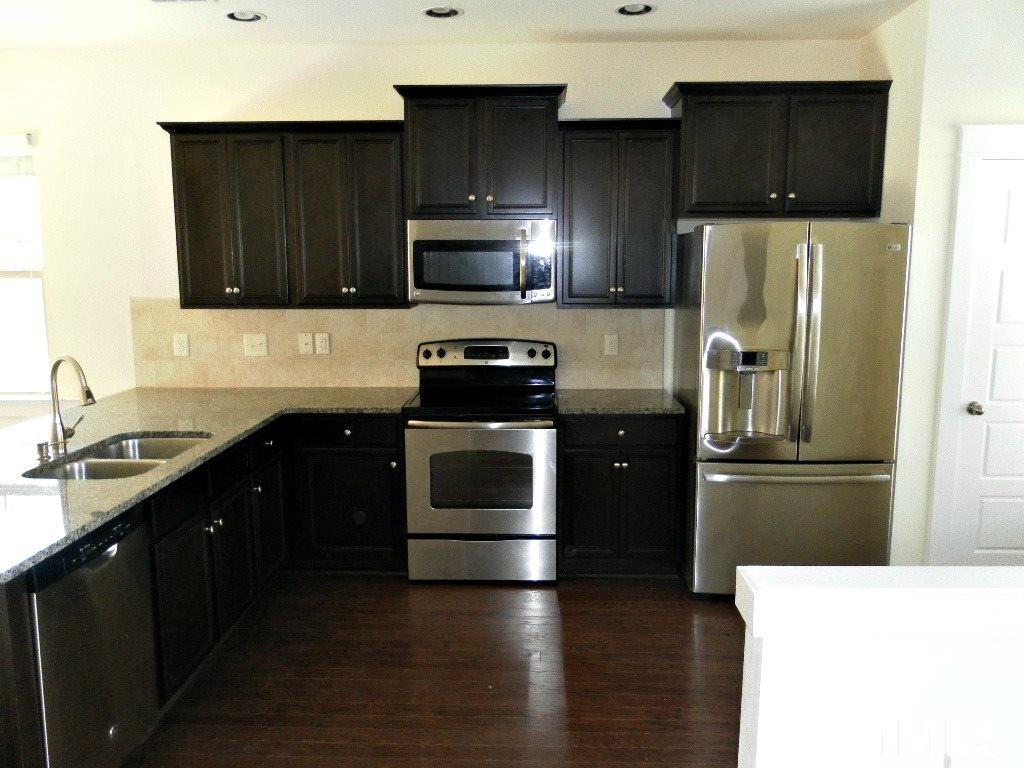 7828 Allscott Way Raleigh, NC 27612 - Photo 7 of 17 a kitchen with a sink and a refrigerator