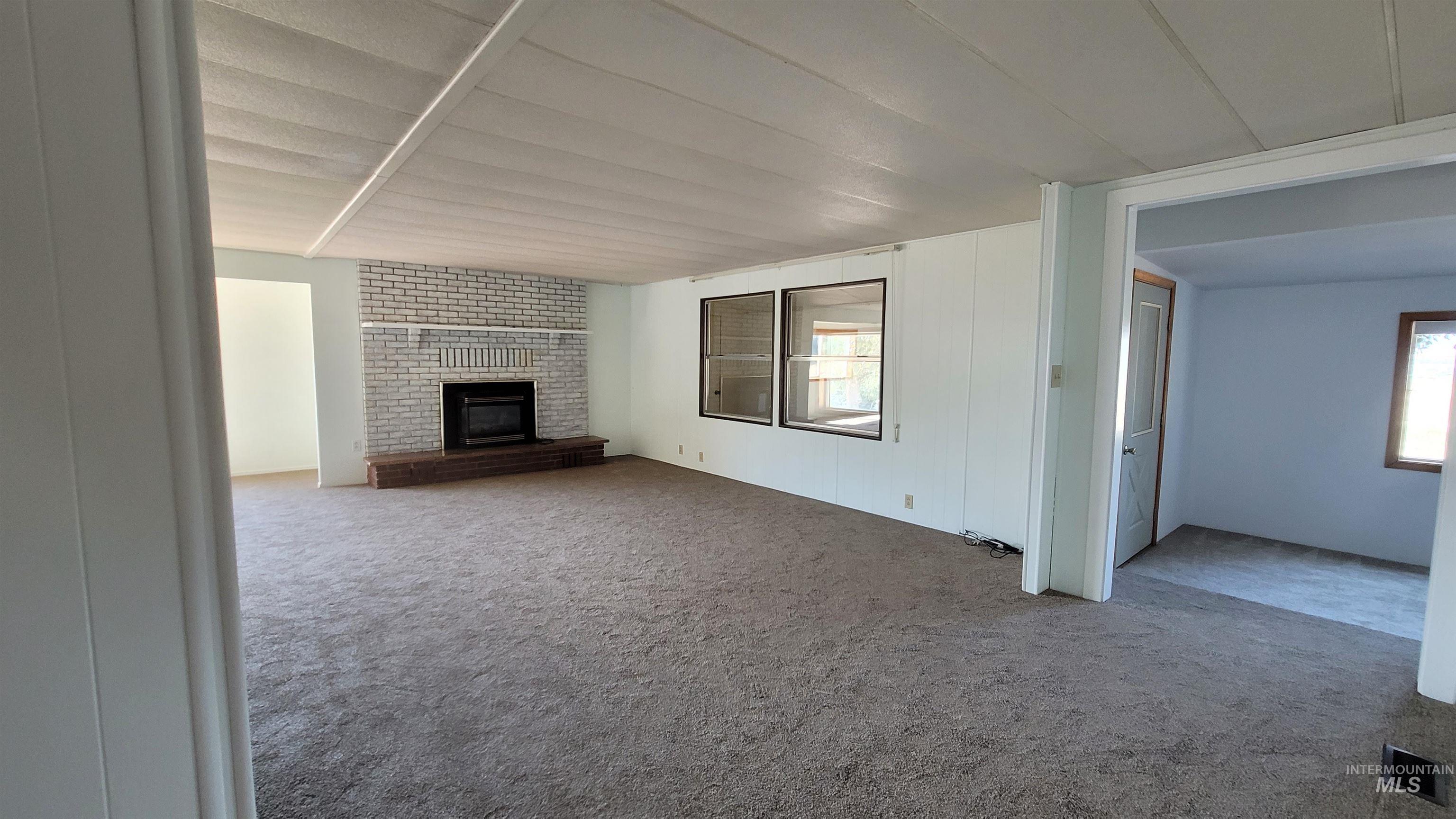 2122 Highway 95 Council, ID 83612 - Photo 11 of 31 Unfurnished living room featuring a brick fireplace and carpet