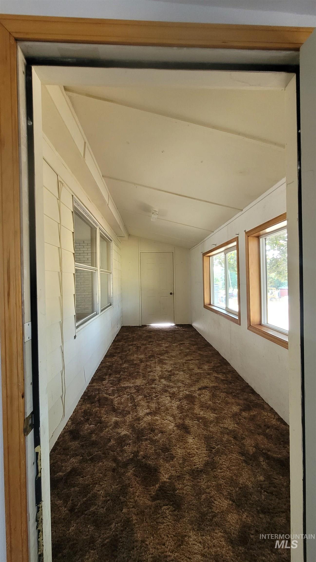 2122 Highway 95 Council, ID 83612 - Photo 21 of 31 Spare room featuring vaulted ceiling and dark colored carpet