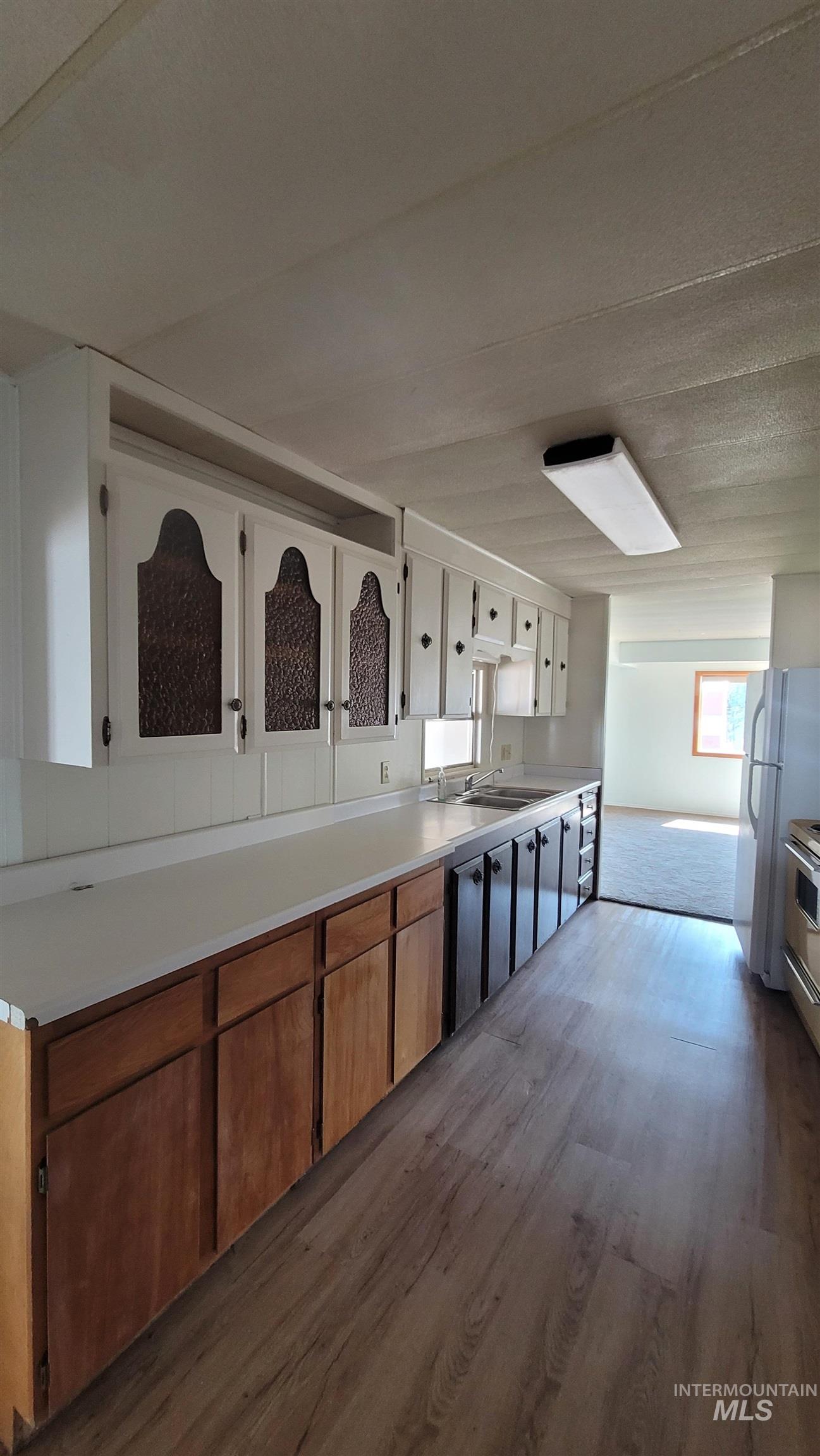 2122 Highway 95 Council, ID 83612 - Photo 23 of 31 Kitchen with light countertops, brown cabinetry, dark wood-type flooring, white cabinets, and stainless steel gas stove
