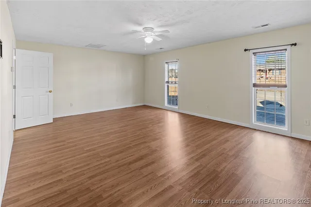 a view of an empty room with wooden floor