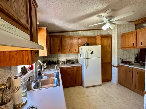 a kitchen with a refrigerator a stove top oven a sink and dishwasher