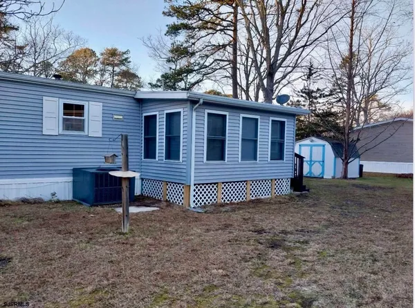 a view of a house with a yard and wooden fence