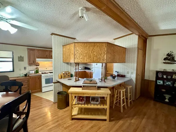 a view of a kitchen with stainless steel appliances granite countertop a stove and refrigerator