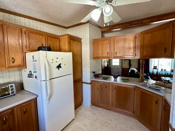 a kitchen with a refrigerator a stove a sink cabinets and a dining table