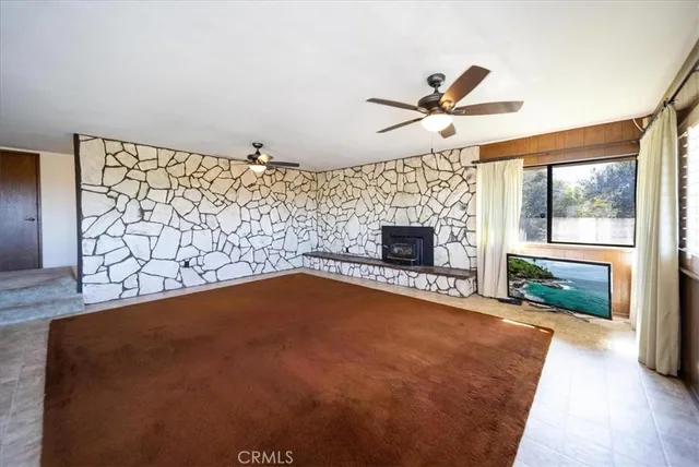 a large room with chandelier fan and wooden floor