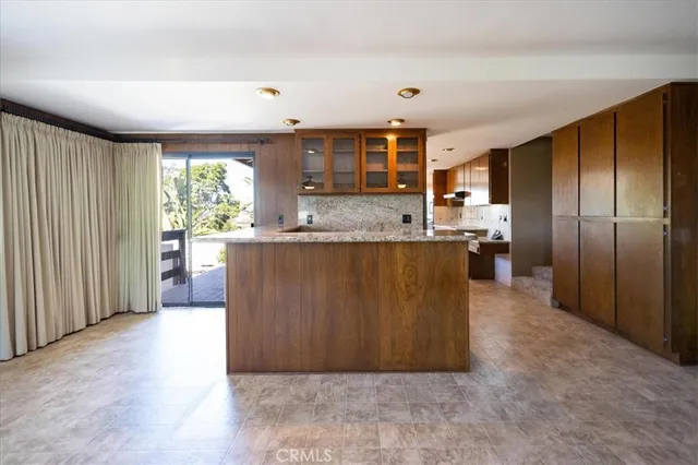 a kitchen with stainless steel appliances granite countertop a sink and a large window