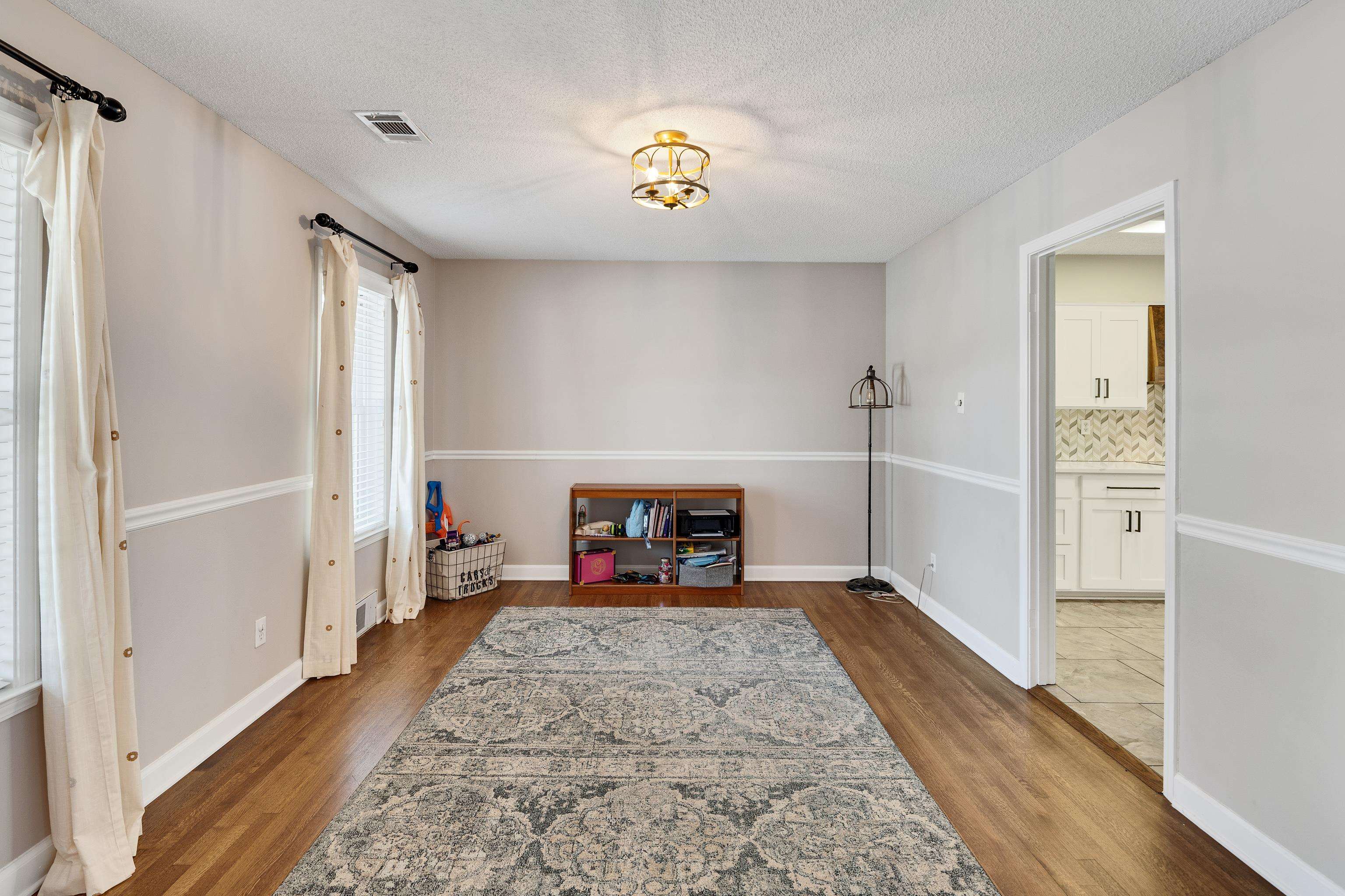 3888 Appling Road Bartlett, TN 38135 - Photo 5 of 21 a view of a hallway to a livingroom with wooden floor and a ceiling fan
