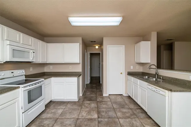 a kitchen with a stove sink and cabinets