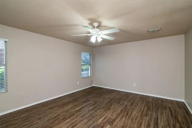 a view of a room with wooden floor and a ceiling fan