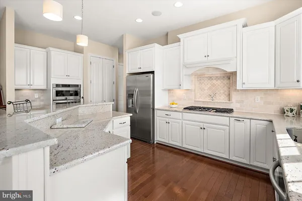 a dining room with wooden floor a chandelier a wooden table and chairs