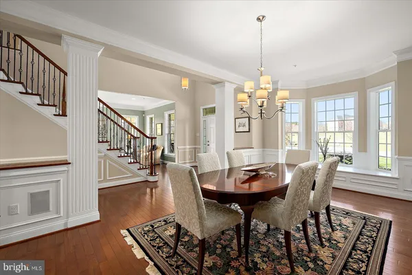 a kitchen with stainless steel appliances kitchen island granite countertop a dining table chairs and sink