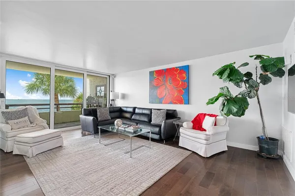 a living room with furniture floor to ceiling window and a flat screen tv