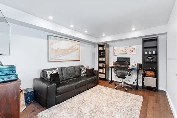 a living room with furniture a desk and chair with wooden floor