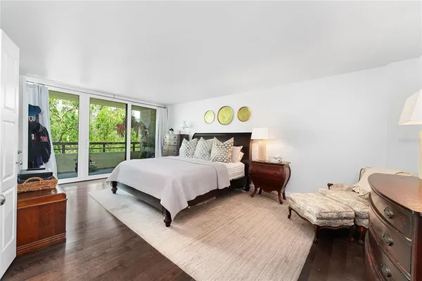 a bedroom with a bed and large windows