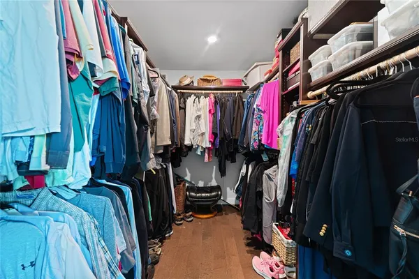 a view of walk in closet with clothes and shoes
