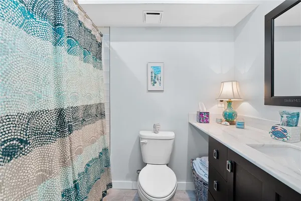 a bathroom with a sink vanity mirror and toilet