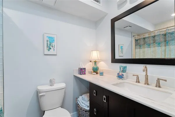 a bathroom with a granite countertop toilet sink and a mirror