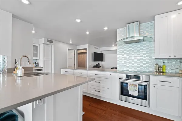 a kitchen with stainless steel appliances granite countertop a sink a stove and cabinets