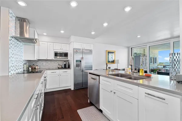 a kitchen with white cabinets and white appliances
