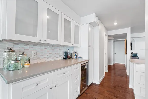 a kitchen with white cabinets and sink