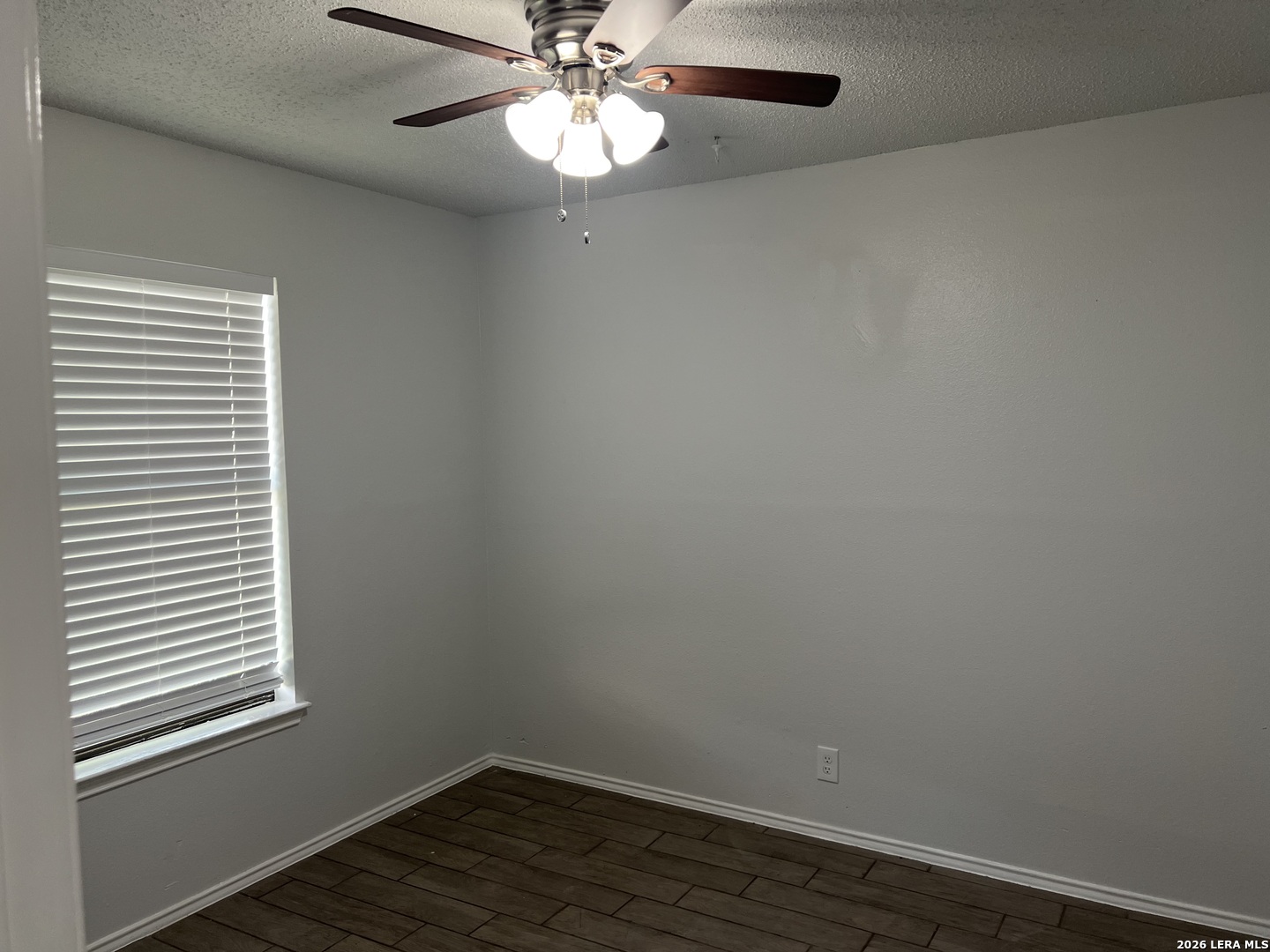 108-110 Whisper Way Boerne, TX 78006 - Photo 13 of 15 an empty room with wooden floor chandelier fan and windows