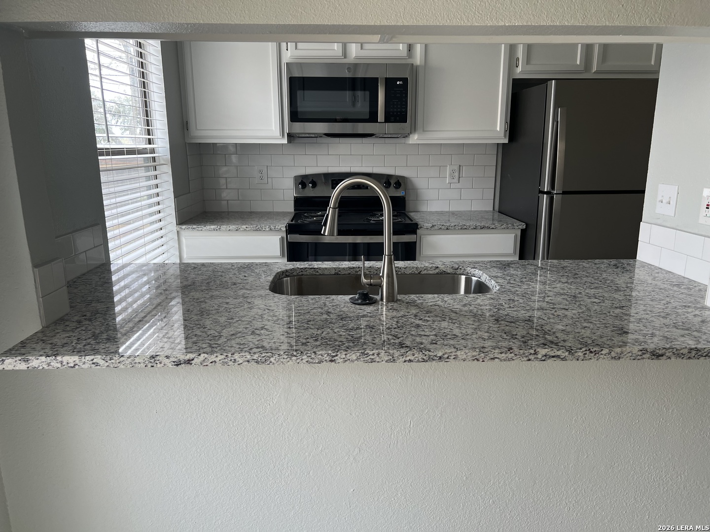 108-110 Whisper Way Boerne, TX 78006 - Photo 3 of 15 a kitchen with a sink a refrigerator and a microwave