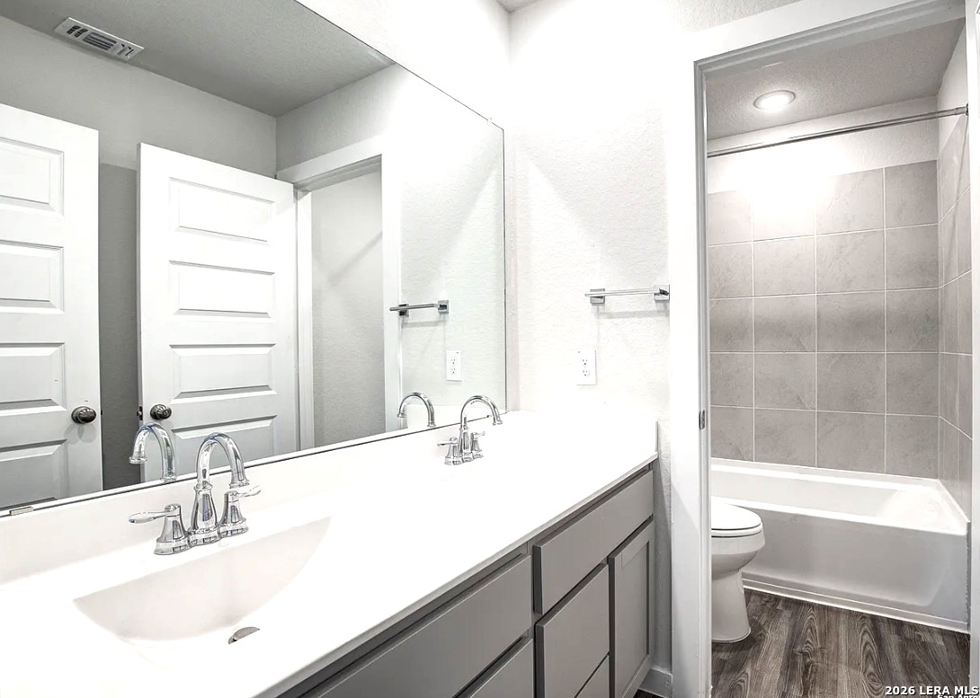 2563 Rambo Drive San Antonio, TX 78224 - Photo 18 of 21 a bathroom with a bathtub shower sink vanity and toilet