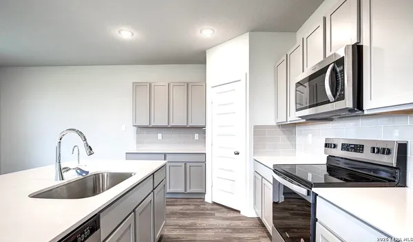 a kitchen with stainless steel appliances granite countertop a sink stove and cabinets