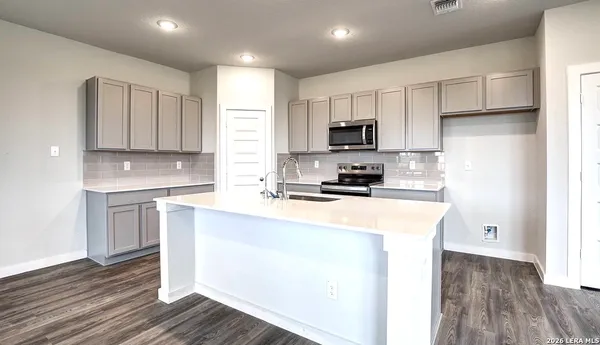 a kitchen with stainless steel appliances granite countertop a sink a stove a refrigerator and cabinets