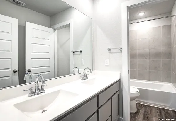 a bathroom with a sink a toilet and a large mirror