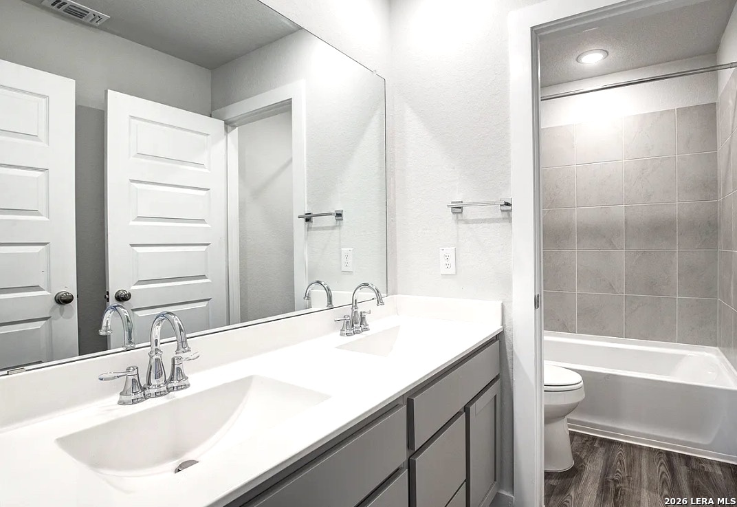 2563 Rambo Drive San Antonio, TX 78224 - Photo 10 of 21 a bathroom with a sink a toilet and a large mirror