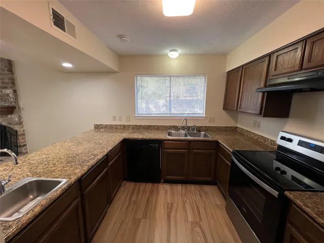 a kitchen with granite countertop stainless steel appliances and sink
