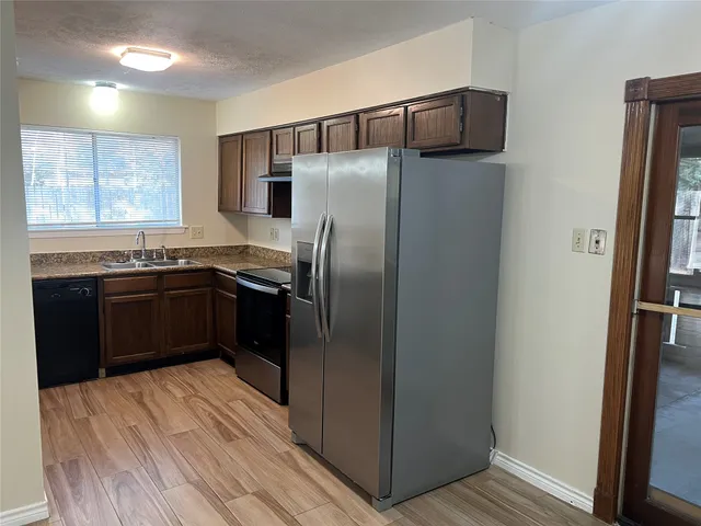 a kitchen with stainless steel appliances granite countertop a refrigerator and a sink