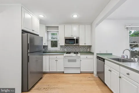 a kitchen with stainless steel appliances granite countertop a refrigerator sink and microwave