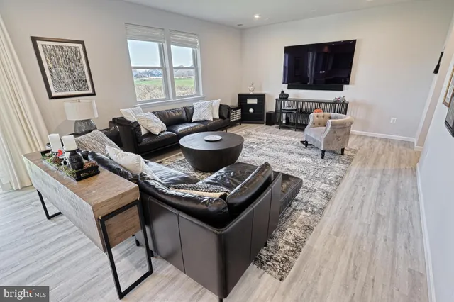a living room with furniture a flat screen tv and a large window