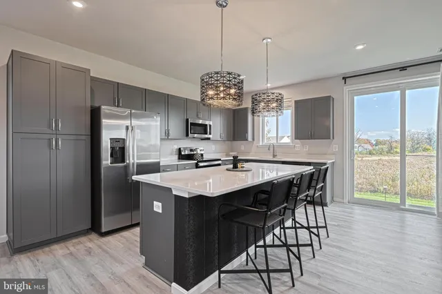 a kitchen with a center island and stainless steel appliances