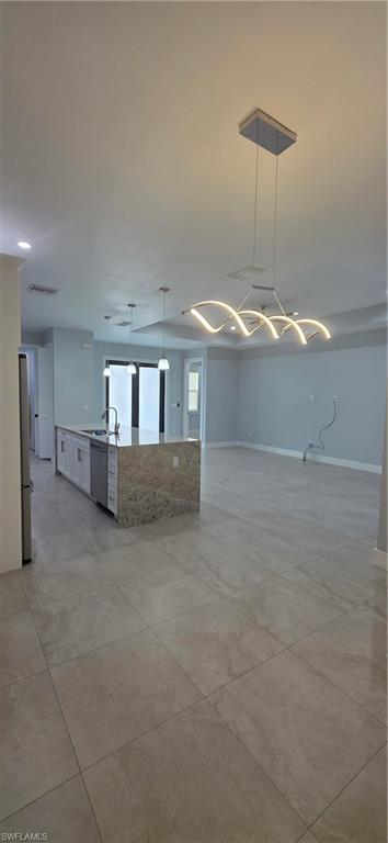 598 2nd Street Southeast Naples, FL 34117 - Photo 16 of 40 Unfurnished living room featuring baseboards and a sink