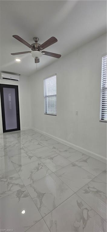 598 2nd Street Southeast Naples, FL 34117 - Photo 32 of 40 Unfurnished room with light marble finish flooring, an AC wall unit, and ceiling fan