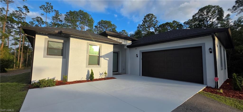 598 2nd Street Southeast Naples, FL 34117 - Photo 4 of 40 View of front facade with roof with shingles, stucco siding, and driveway