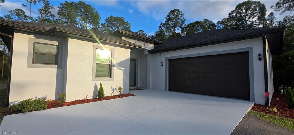 598 2nd Street Southeast Naples, FL 34117 - Photo 5 of 40 View of front of house with stucco siding, driveway, and a shingled roof
